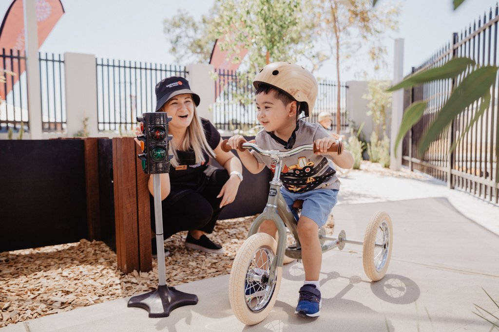 Child on bike and educator